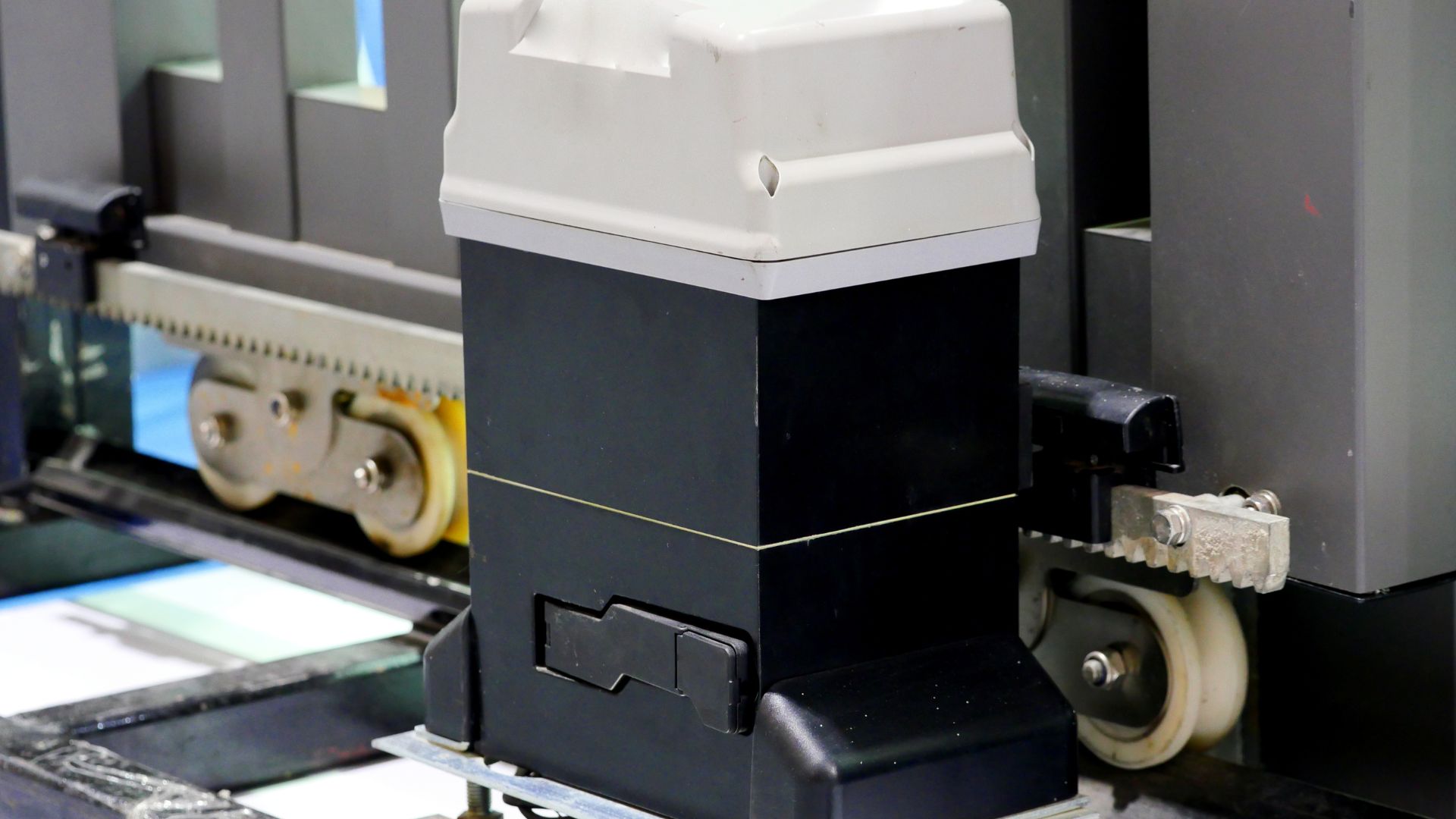 Industrial printing machine with white and black components and mechanical parts
