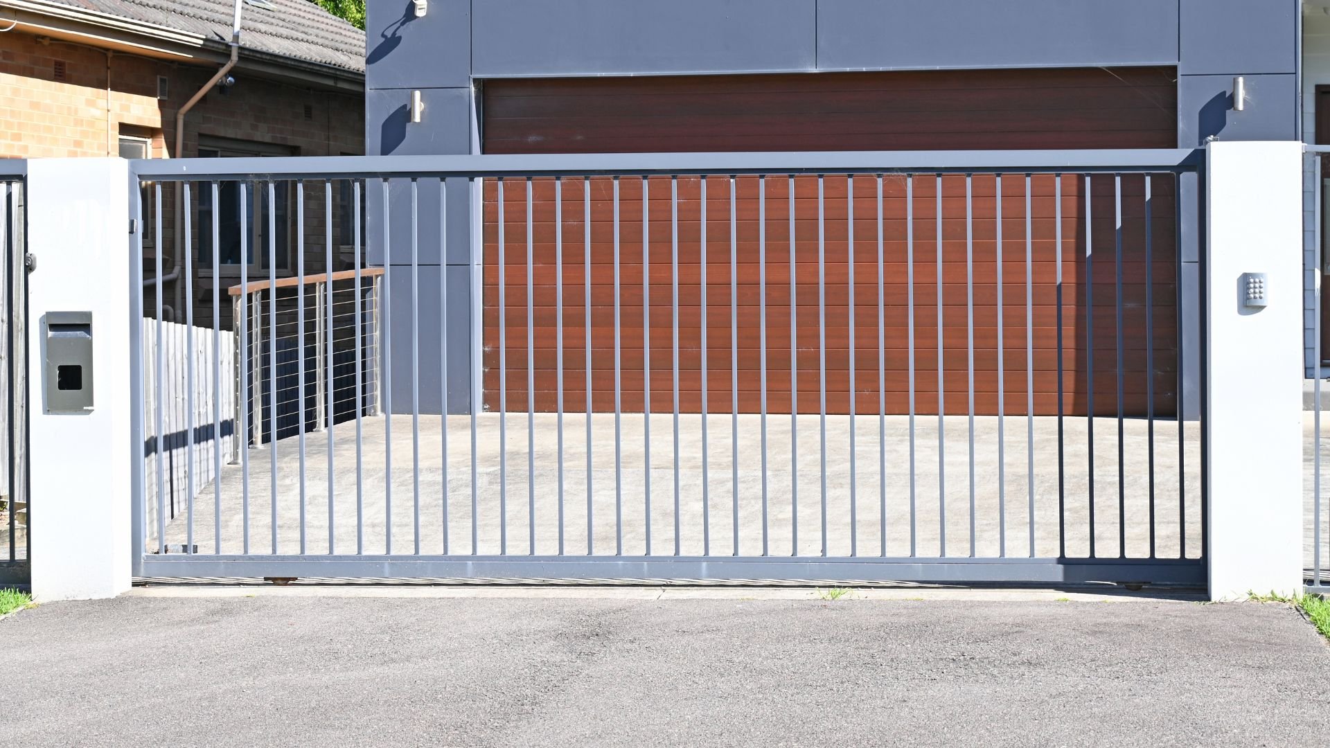Modern sliding gate with metal bars and wooden slats in front of building